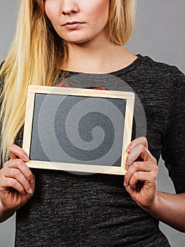 Woman holding blank black board