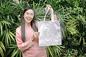 woman holding blank cotton eco tote bag. environment concept design mockup