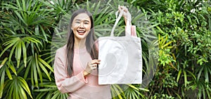 woman holding blank cotton eco tote bag. environment concept design mockup