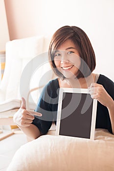 Woman holding blank digital tablet with finger point.