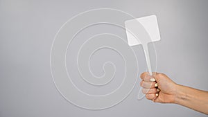 Woman holding blank sign on white background. Copy space.