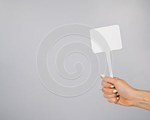 Woman holding blank sign on white background. Copy space.