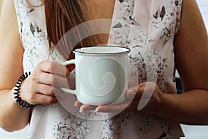 Woman holding blank white coffee mug mockup. White mug mock up for your company logo and design