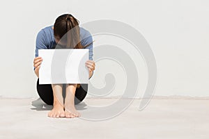 Woman holding blank white sign with her head buried in defeat