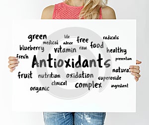 Woman holding a board with Antioxidants concept