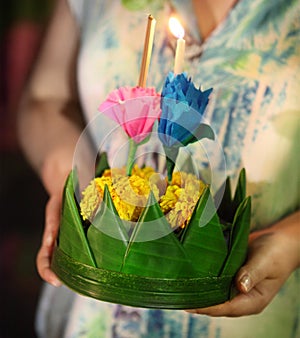 Woman holding boat with candles and flowers are given for Thailands traditional Loy Krathong Festival