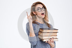 Woman holding books and pointing finger up