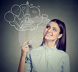 Woman holding bottle of perfume and smelling aroma