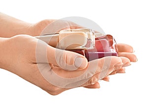 Woman holding bottles of colorful nail polishes on white background