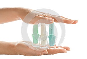 Woman holding bottles of colorful nail polishes on white background