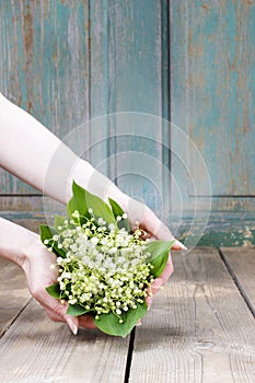 Woman holding bouquet of lily of the valley flowers