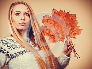 Woman holding bouquet made of autumn leaves