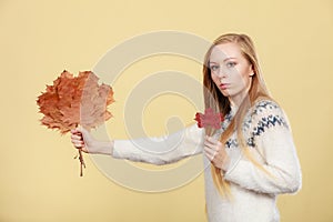 Woman holding bouquet made of autumn leaves