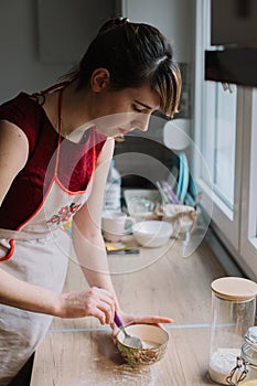 Woman holding the bowl with food and mixing