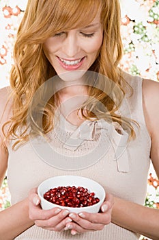 Woman holding bowl of pomegranate seeds