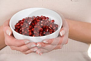 Woman holding bowl of pomegranate seeds