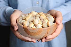 Woman holding bowl with shelled organic Macadamia nuts