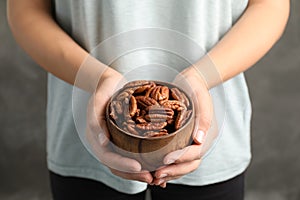 Woman holding bowl with shelled pecan nuts