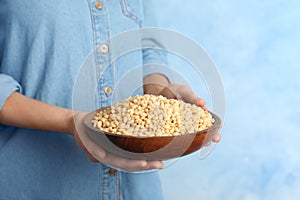 Woman holding bowl with shelled pine nuts