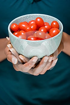 Woman holding bowl of tomatoes