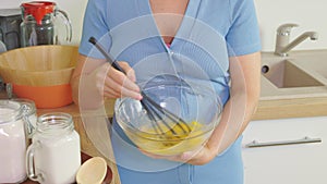 Woman holding bowl whisking milk and eggs