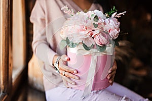 woman holding a box with artificial flowers in her hands