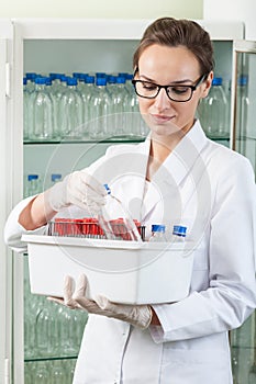 Woman holding box with laboratory equipment