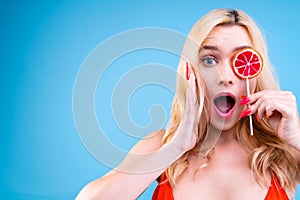 Woman is holding bright colorful lollipop