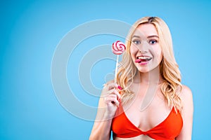 Woman is holding bright colorful lollipop