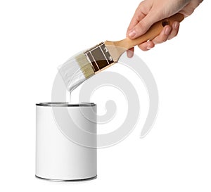 Woman holding brush over paint can on white background.