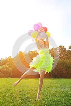 Woman holding bunch of colorful air balloons