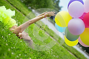 Woman holding bunch of colorful air balloons