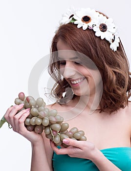 Woman holding bunch of grapesand looking on it