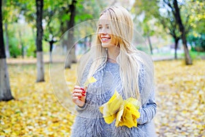 Woman holding bunch of yellow autumn leaves photo