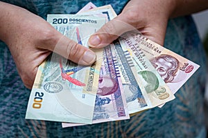 Woman holding a bundle of Honduras banknotes, home budget concept