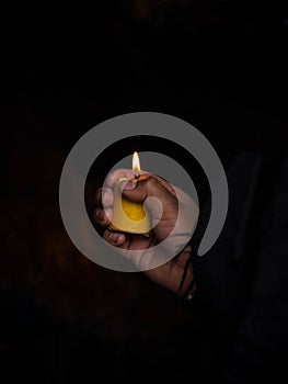 Woman holding burning candle in her hands memory grief religion faith belief in Las Lajas Sanctuary Ipiales Colombia