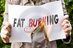 Woman is holding a burning paper with text