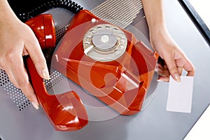 Woman holding business card and dialing