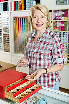 Woman holding buttons and clasps