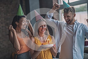 Woman holding a cake with candles at her birthday party