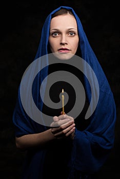 Woman holding candle and praying