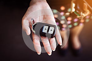 Woman holding a car key on hand