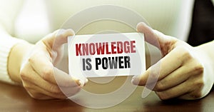 Woman holding card with Knowledge is power text on grey background. Mock up for design