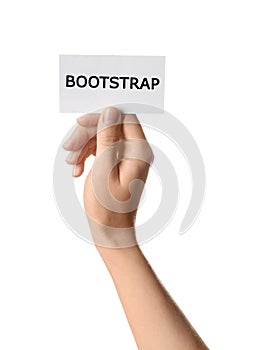 Woman holding card with word BOOTSTRAP on background, closeup photo