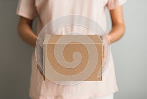 Woman holding a cardboard box, the parcel in hands