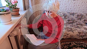 Woman holding cash in front of heating radiator. Payment for heating in winte