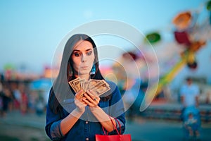 Woman Holding Cash Money at Summer Funfair