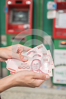 Woman holding cash withdrawn from ATM photo