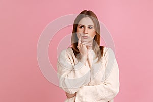 Woman holding chin, pondering idea, planning strategy, musing and solving difficult question in mind