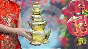 Woman holding Chinese new year gold ingots in chinatown